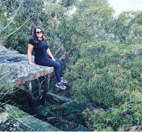 A person sitting on a rock

Description automatically generated
